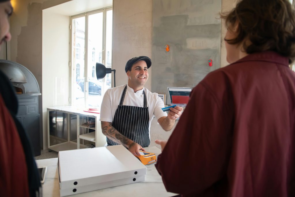 Barista using PAX A920 PRO card machine for contactless payment in Irish café showing card machine costs Ireland
