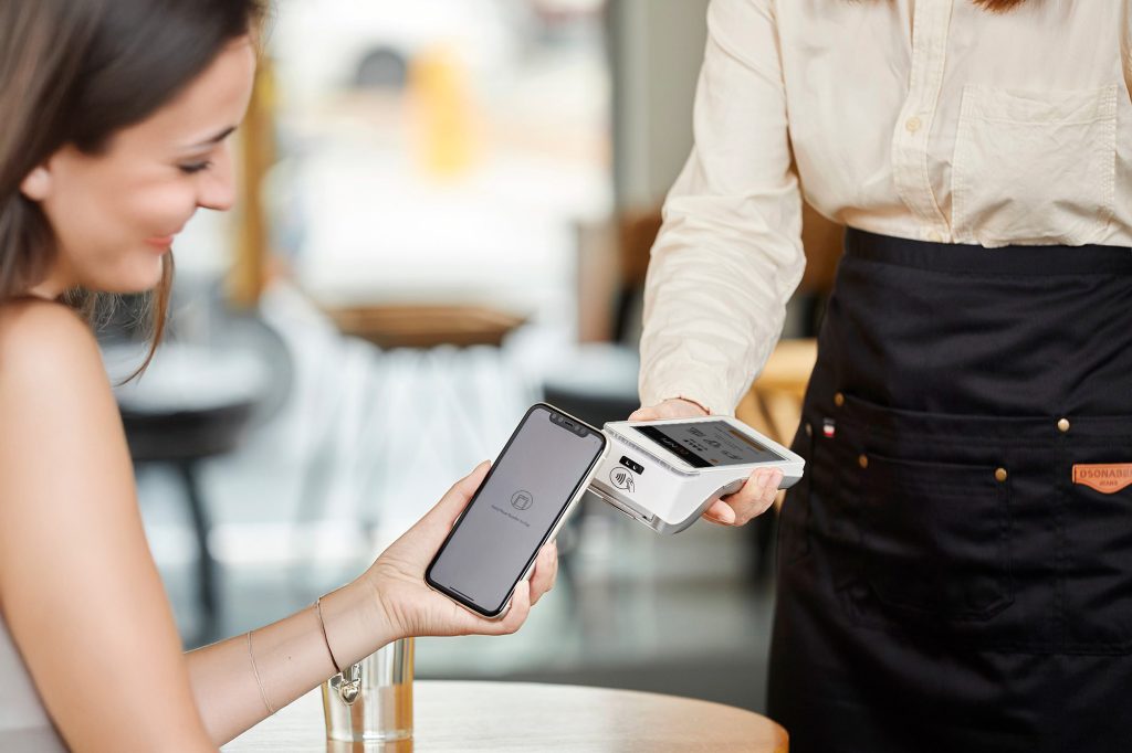 Customer making a contactless payment on a PAX A920 PRO, highlighting transparent payment processing costs Ireland businesses trust